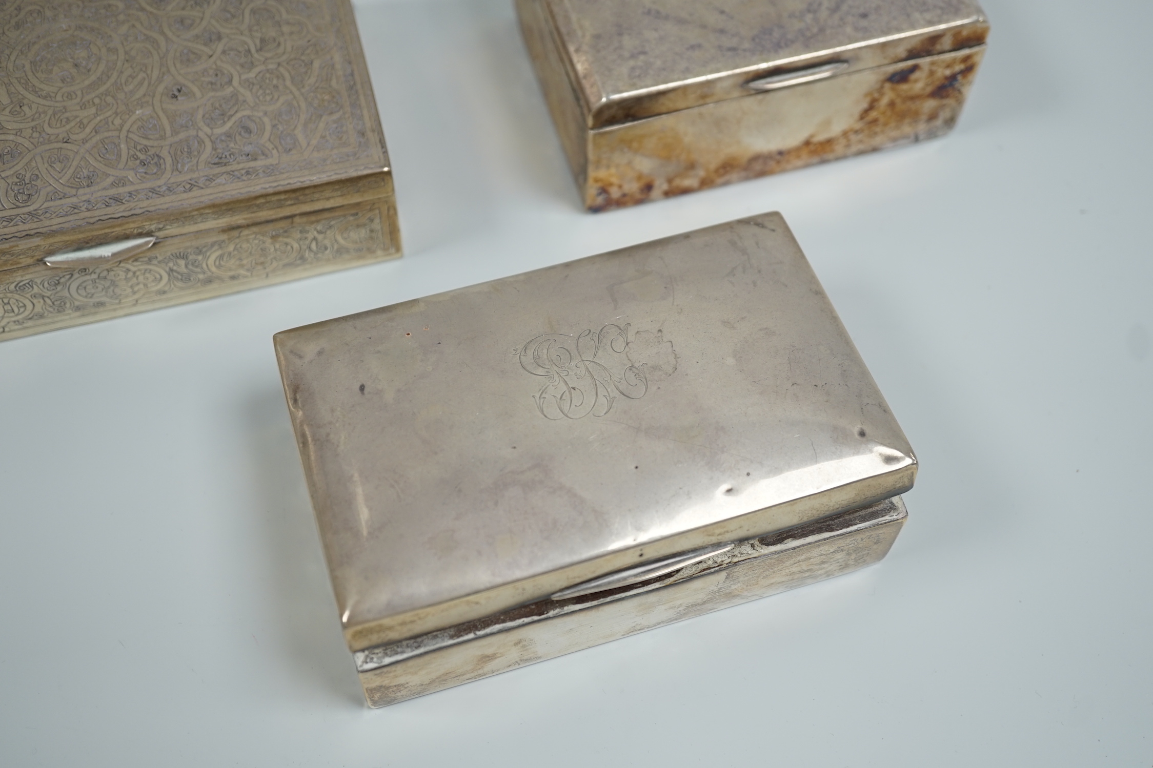 A George V silver mounted cigarette box, 13.9cm, a Persian engraved white metal cigarette box and one other cigarette box.